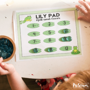 Preschool Learning Games using printable board game with green lily pads, dice, frog pieces and green frogs.