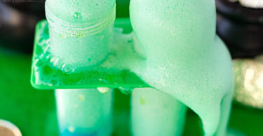 Looking for a fun st patricks day activity to show kids how two seperate colors make a new color? This colour mixing experiment is perfect for March. Children will not only mix blue and yellow to make green, but they will get to enjoy a fun chemical reaction with the baking soda and vinegar to make a fun eruption. This St Patricks Day Science is perfect for toddler, preschool, pre-k, kindergarten, and first grade students who are just starting to explore sciece. THey will be delighted with this St Patricks day activity for preschoolers!