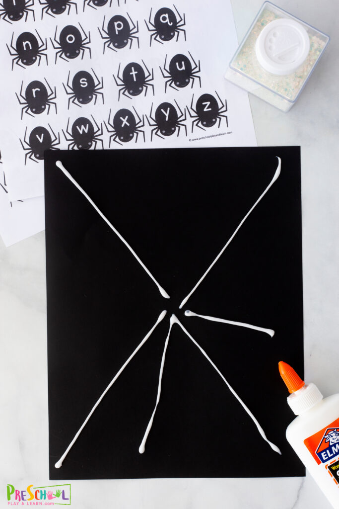 On black construction paper draw a spider web with glue. 