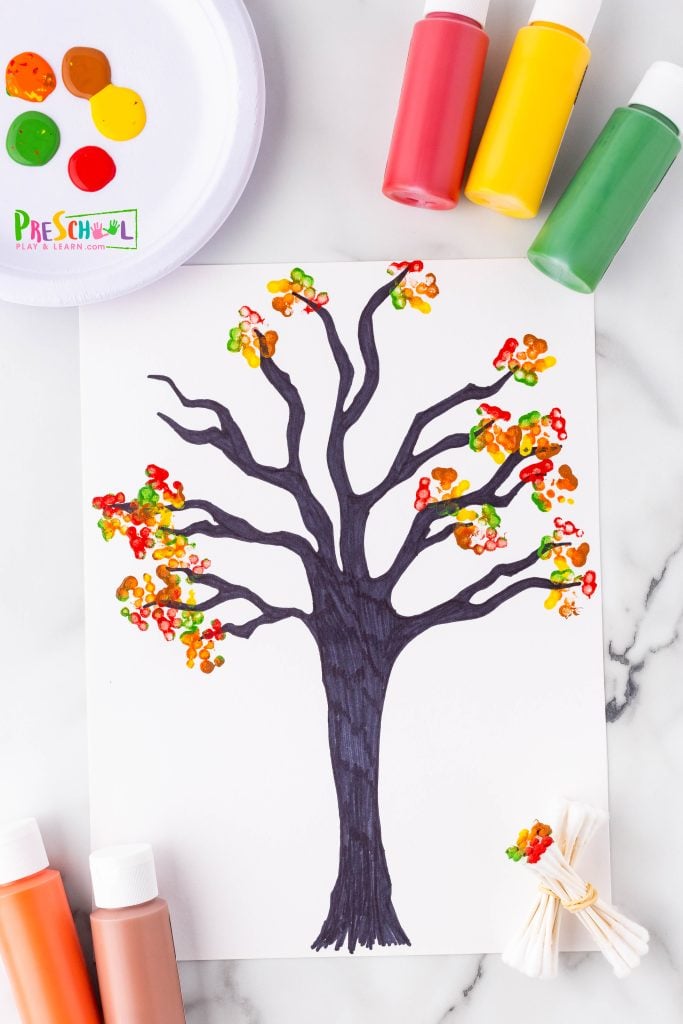 ather a bunch of Q-tips and secure them with a rubber band—this will be your unique paintbrush for a fun art project!

Squeeze some vibrant acrylic paints in yellow, orange, red, brown, gold, and green onto a paper plate. Dip your bundled Q-tips into the colors and gently press them onto your paper to create beautiful fall leaves all around the branches of your tree.